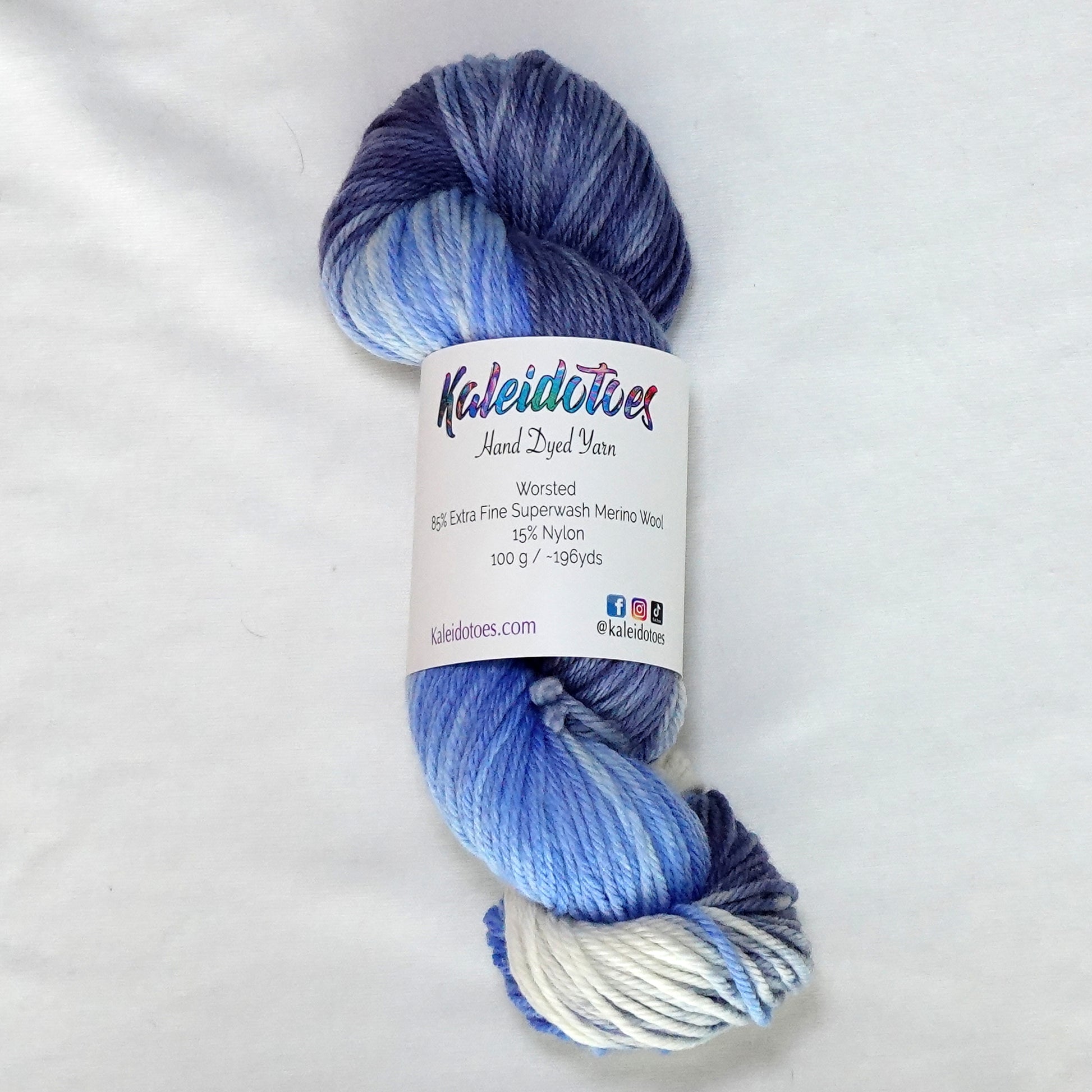 Hand-dyed worsted weight yarn in white, cornflower blue, periwinkle, and deep indigo with a clean gradient transition throughout.