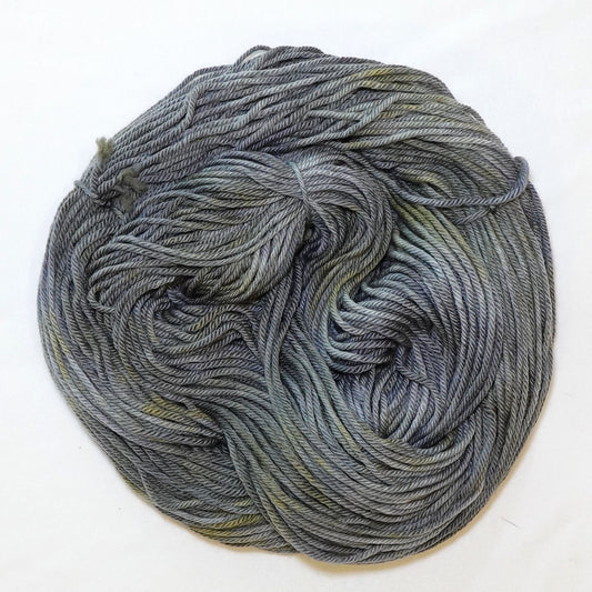 Hand-dyed worsted weight yarn in cool grey with unexpected warm gold undertones and random golden variation.