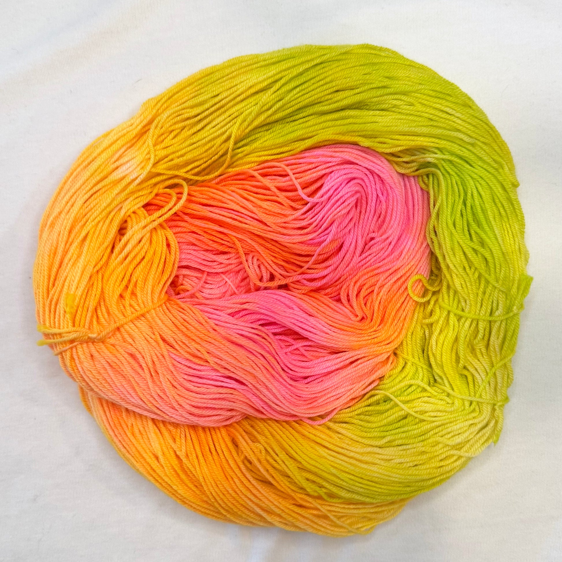 Hand-dyed yarn in mango, tangerine, pink, and lime tones — bright, juicy, and tropical like a summer fruit cocktail.