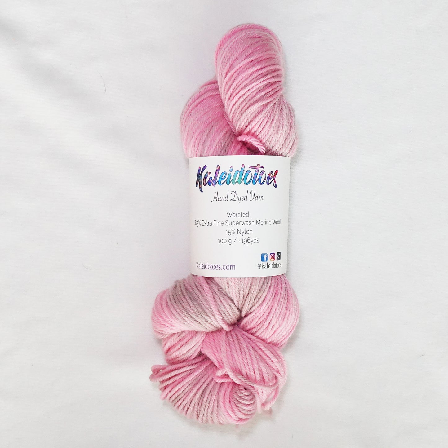 Hand-dyed worsted weight yarn in warm pink and soft taupe with subtle tonal variation throughout.