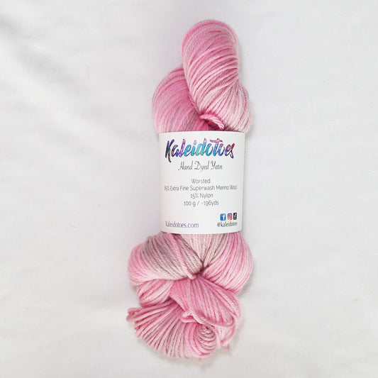 Hand-dyed worsted weight yarn in warm pink and soft taupe with subtle tonal variation throughout.