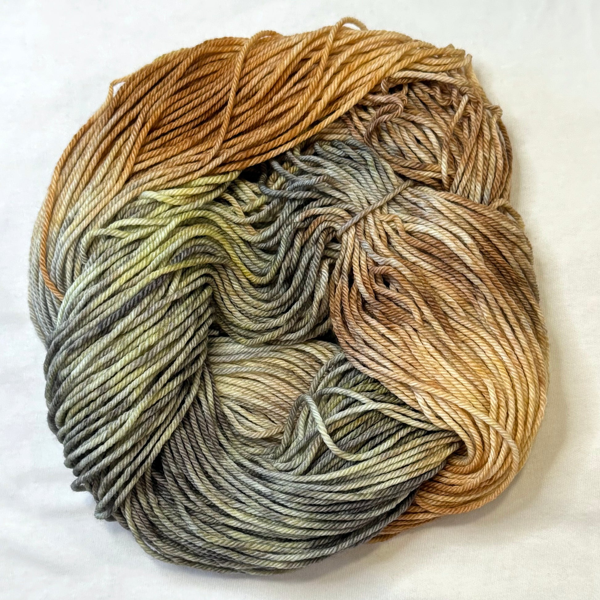 Hand-dyed yarn in soft neutrals, warm browns, and wintery greys inspired by cozy knitted mittens.