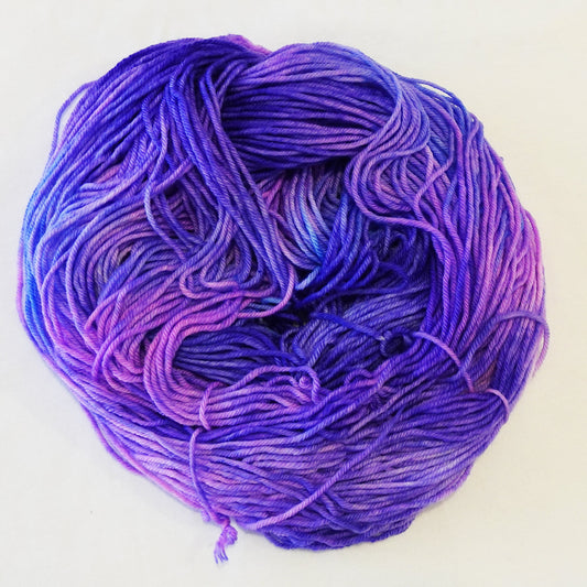 Hand-dyed yarn skein with layered pink and purple tones blended smoothly with soft tonal transitions