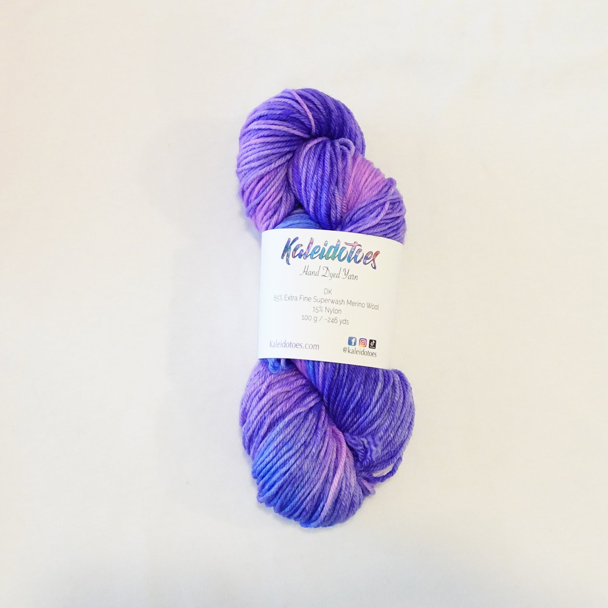 Hand-dyed yarn skein with layered pink and purple tones blended smoothly with soft tonal transitions