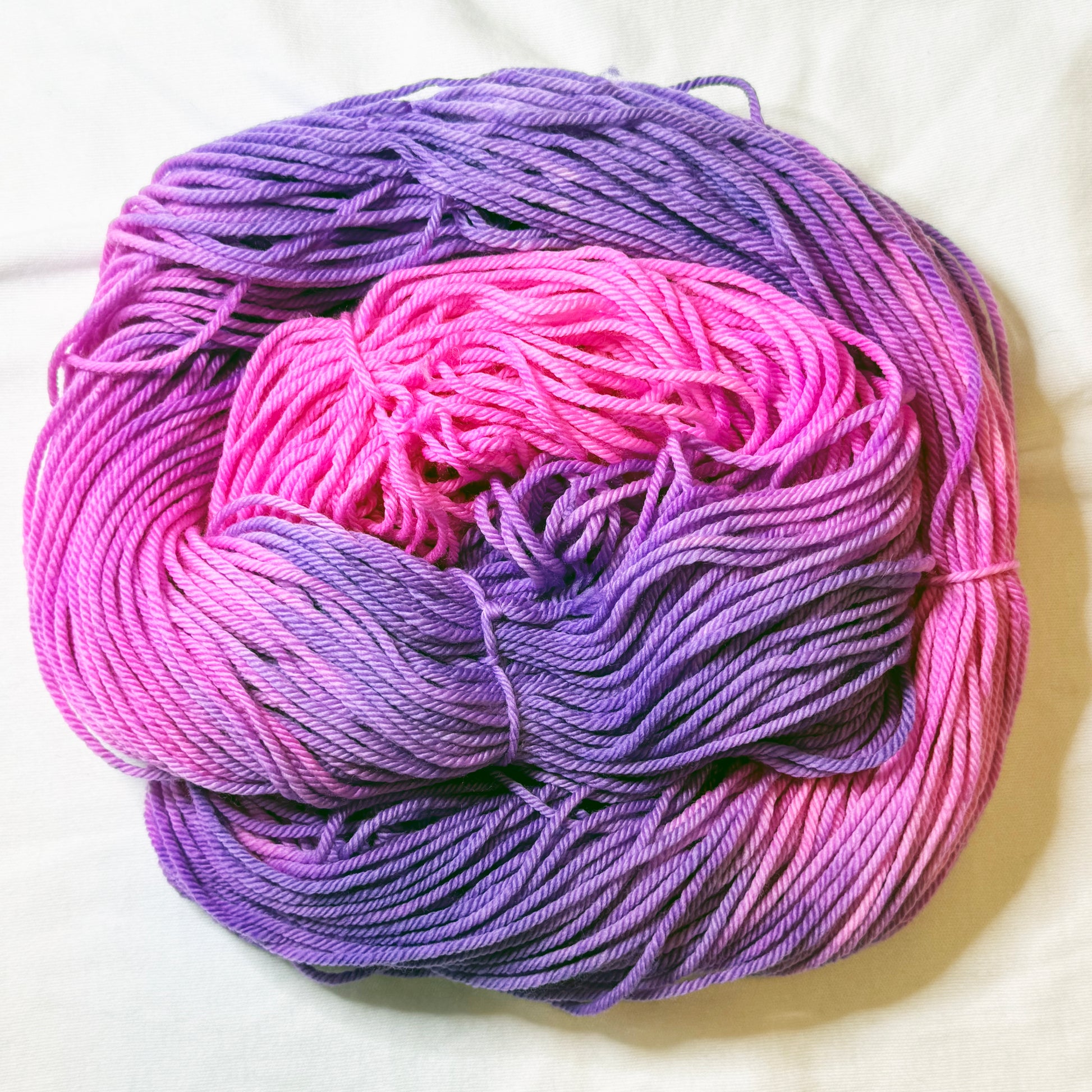 Bloomstruck hand-dyed sock yarn skein in bold magenta, violet, and deep purple tones, small-batch Kaleidotoes yarn made in the USA