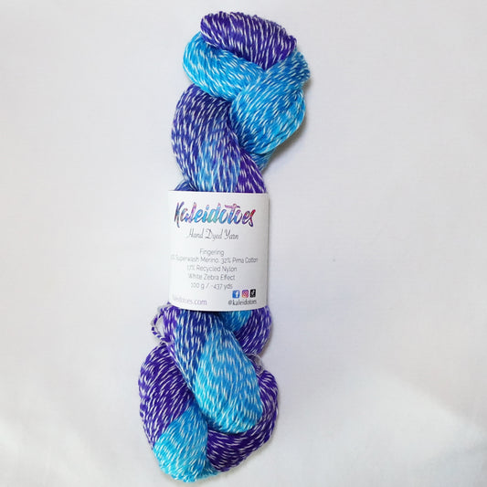 Hand-dyed white zebra base fingering weight yarn in bright turquoise, deep blue, and violet purple with white plied throughout.