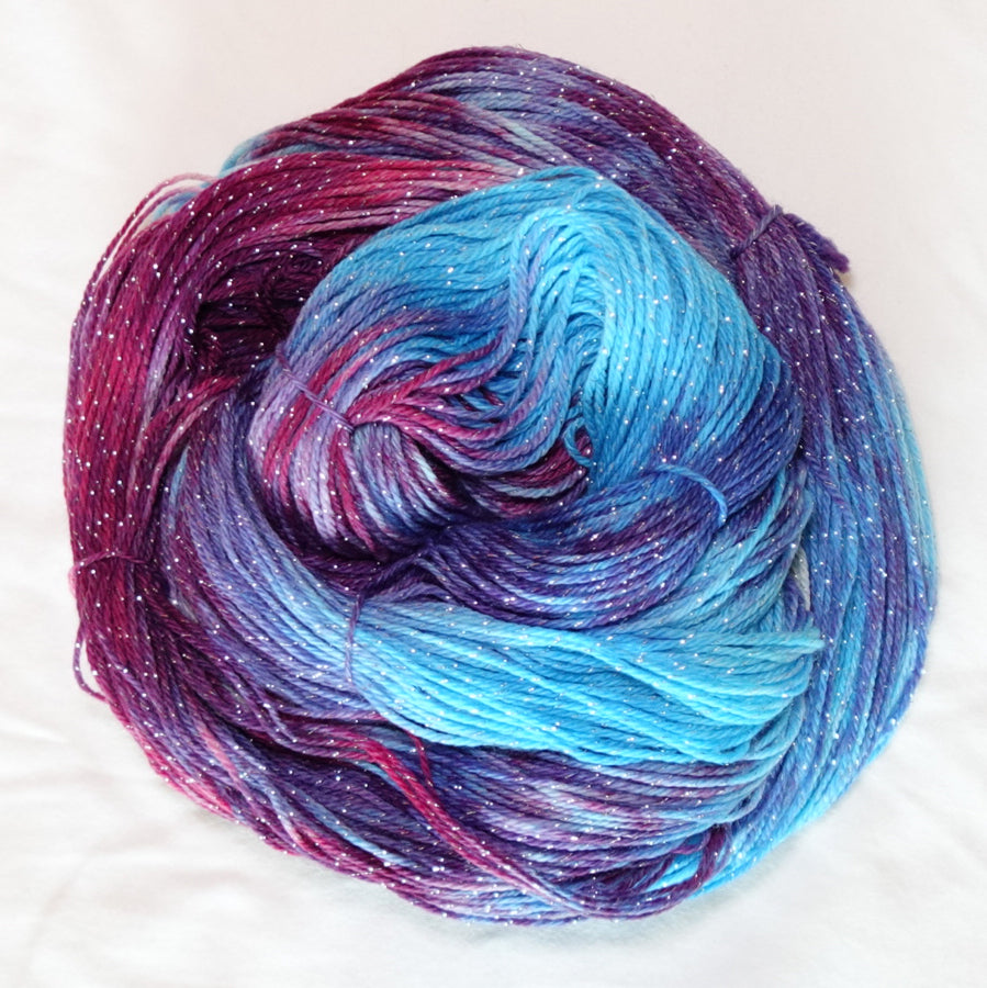 Hand-dyed silver metallic fingering weight yarn in icy blue, rich berry purple and amethyst with a fine silver metallic thread.