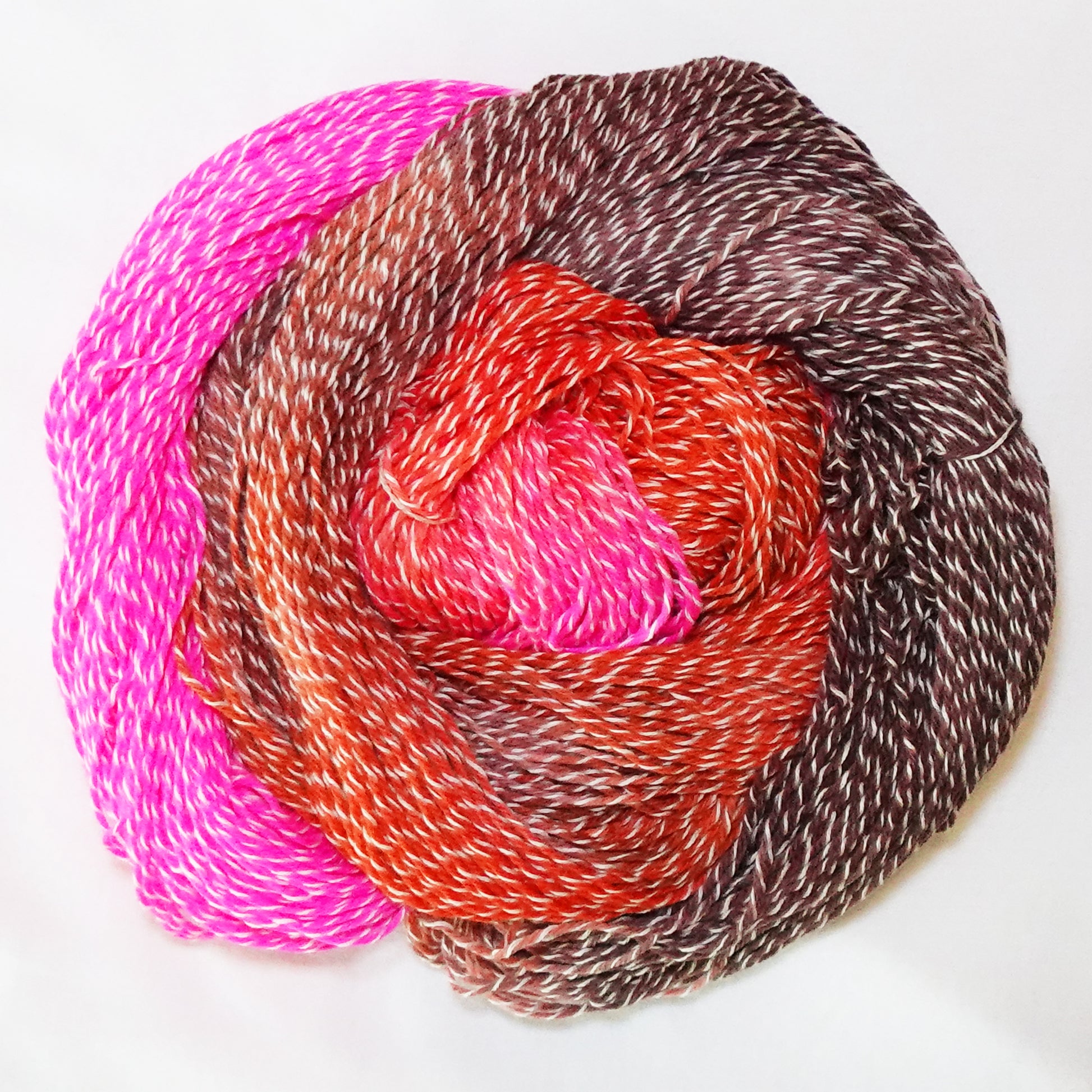 Hand-dyed white zebra base fingering weight yarn in hot pink, bright orange, and coffee brown with white plied throughout.