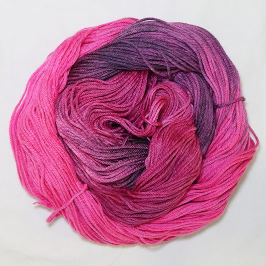 Hand-dyed DK weight yarn in hot pink, deep mauve, and dusty amethyst - vivid, moody, and richly variegated throughout.