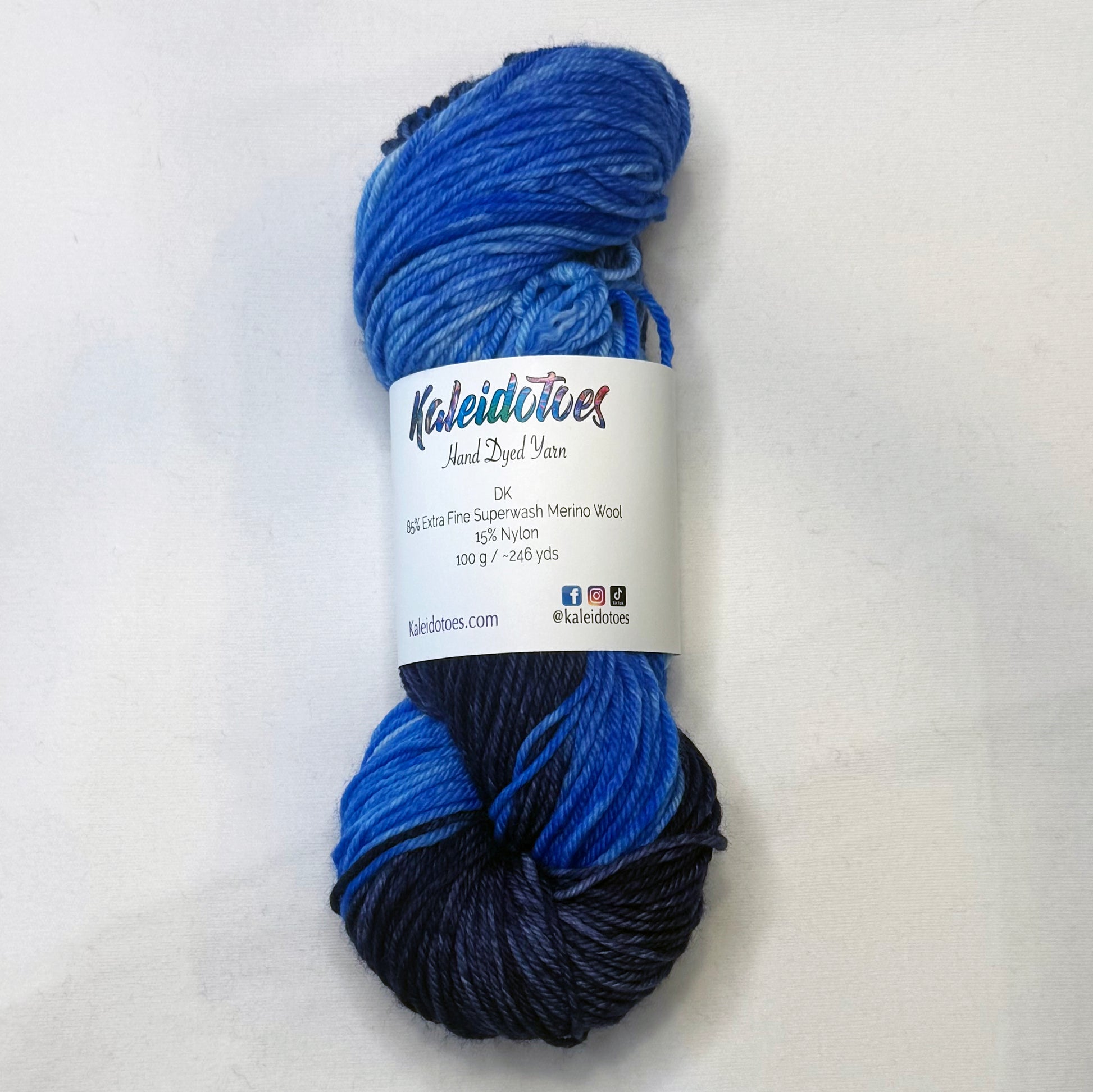 Hand-dyed yarn in deep navy, electric blue, cool blue, and soft white — a luminous blend inspired by moonlight on rippling water.