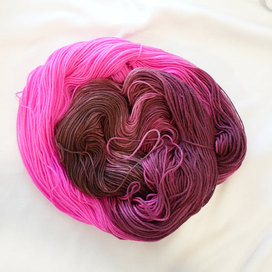 Hand-dyed yarn in deep brown, plum, and electric pink tones — rich and bold with a high-contrast, velvety finish.
