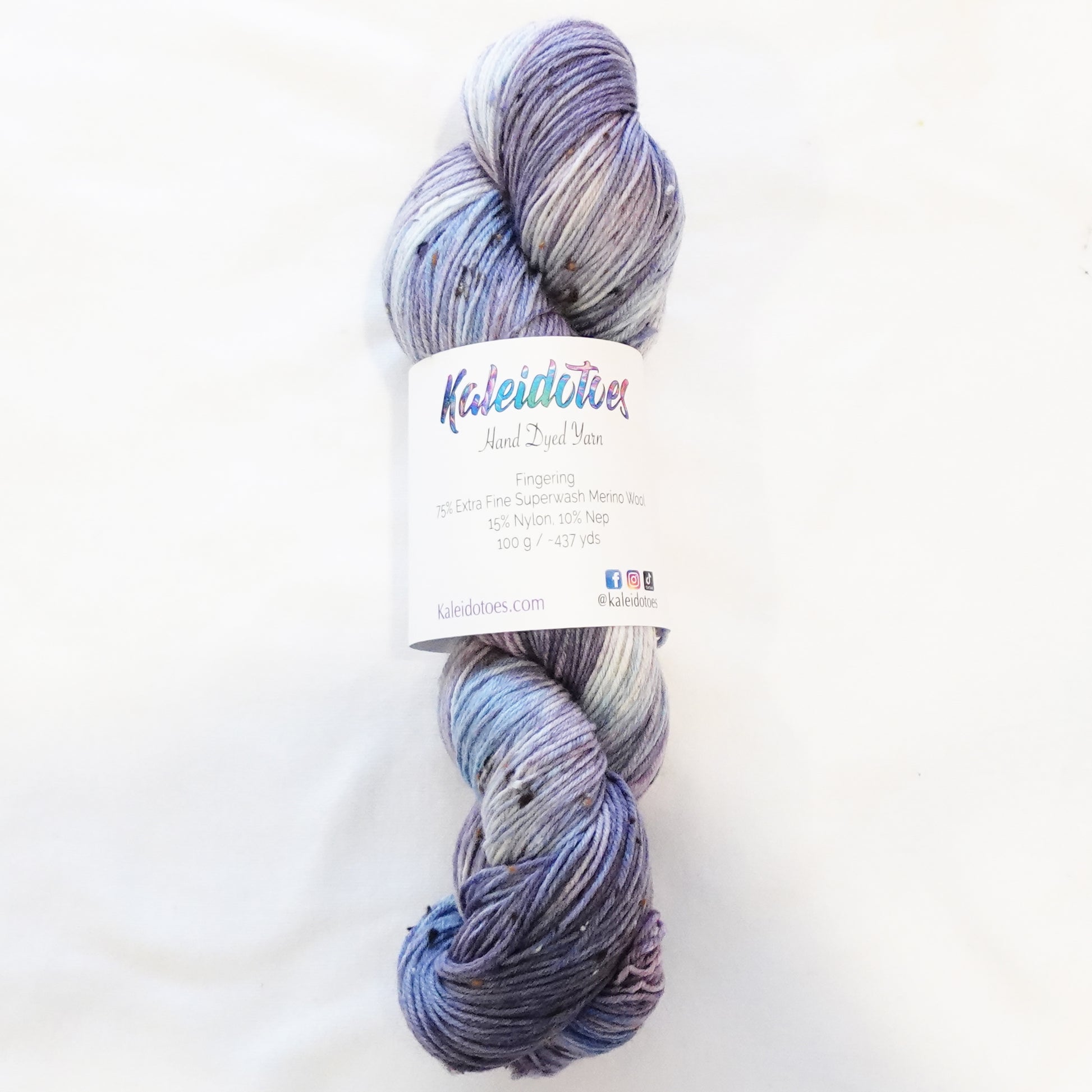 Hand-dyed tweed yarn in dusty mauve and soft grey-blue — muted, atmospheric, and quietly complex with subtle flecks throughout.