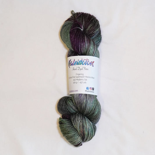 Hand-dyed fingering weight yarn in cactus green, blue-green, olive, and deep aubergine tones.