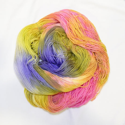 Hand-dyed yarn in vibrant yellow, peach, coral, hot pink, violet, and chartreuse tones — layered and shifting like a classic jawbreaker candy.