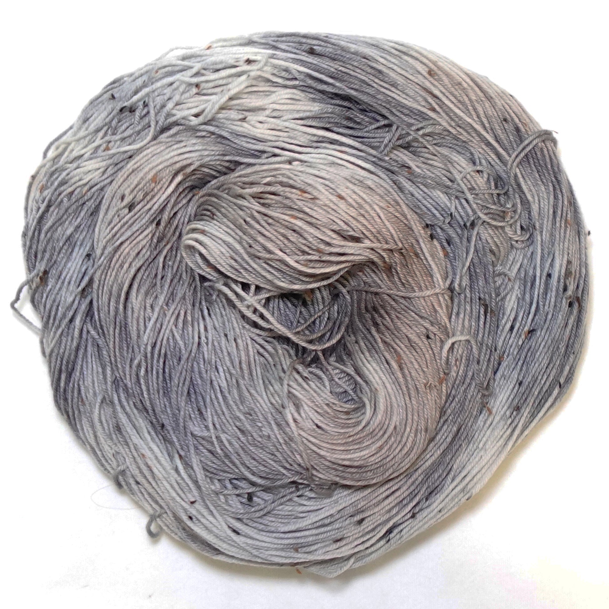 Hand-dyed yarn in soft grey and muted taupe tones — subtle, warm neutrals with gentle variation and a calm, understated feel.