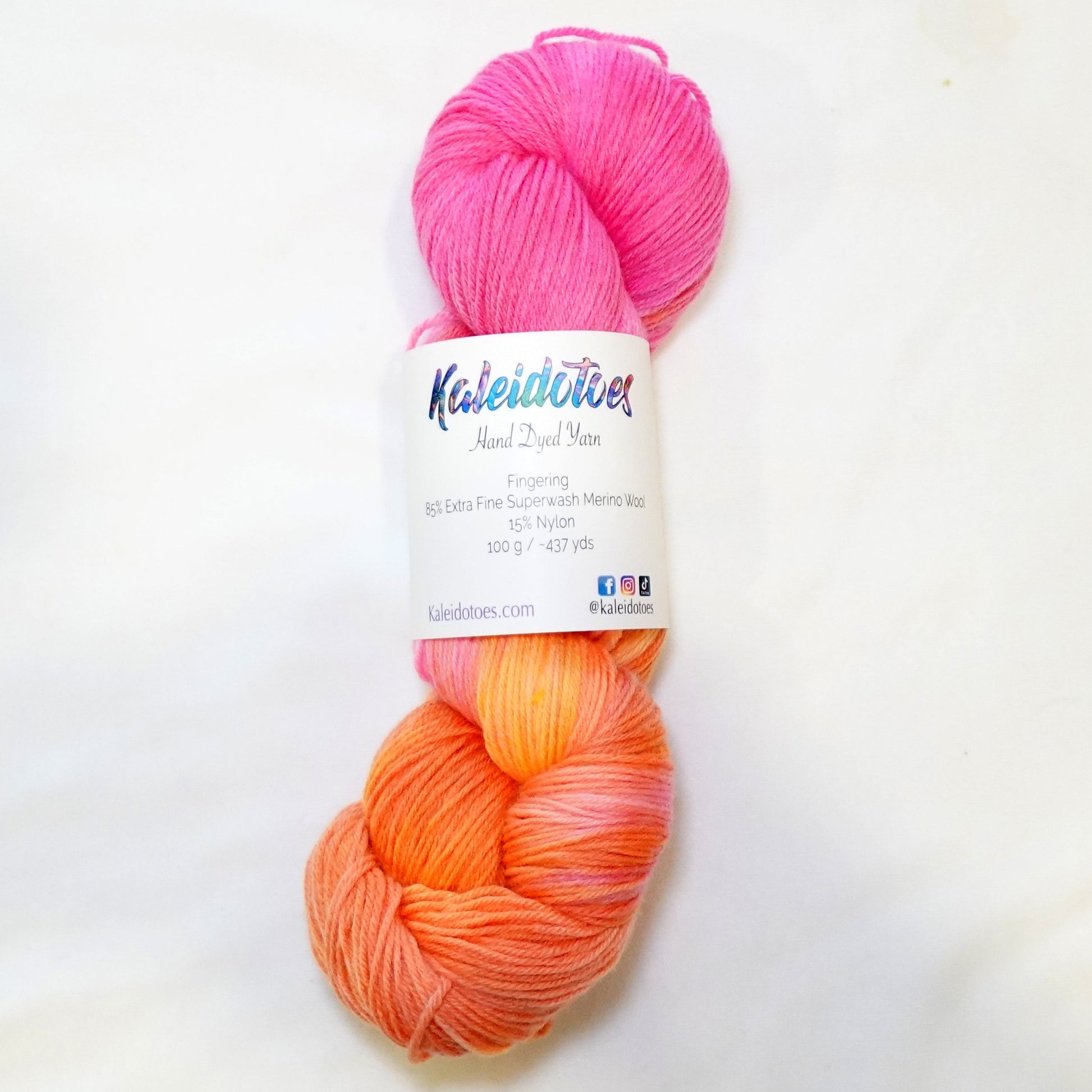 Hand-dyed yarn in soft peach, coral, warm pink, and hints of yellow — blended smoothly like melted taffy candy.