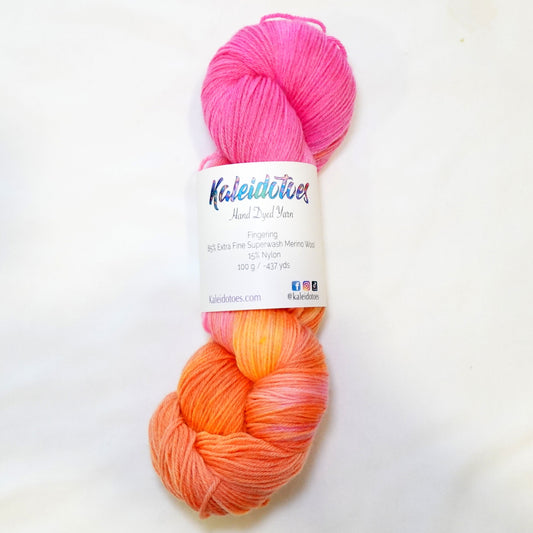 Hand-dyed yarn in soft peach, coral, warm pink, and hints of yellow — blended smoothly like melted taffy candy.