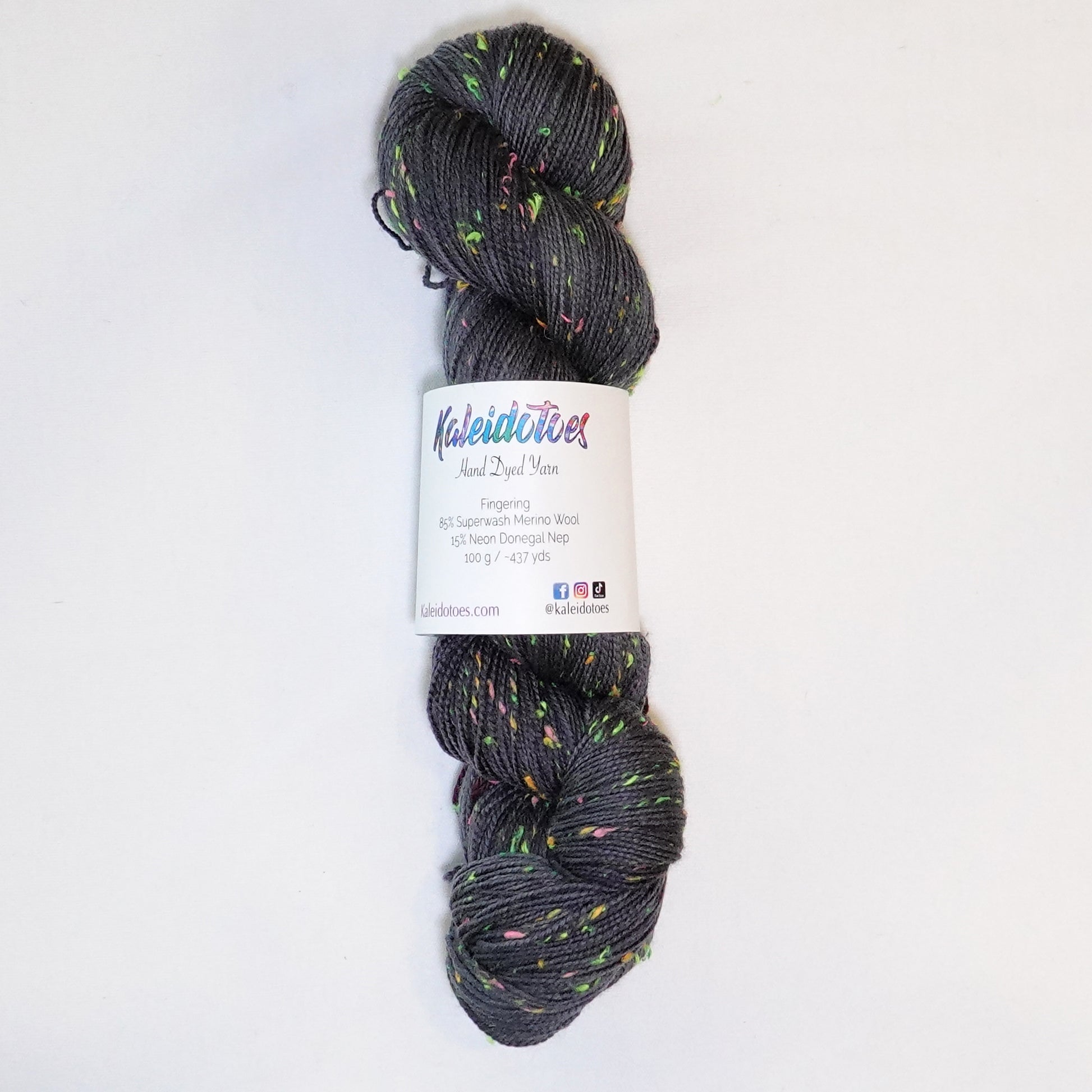 Hand-dyed yarn in deep charcoal with bright flecks of lime, pink, and orange — moody with a disco-inspired pop of color.