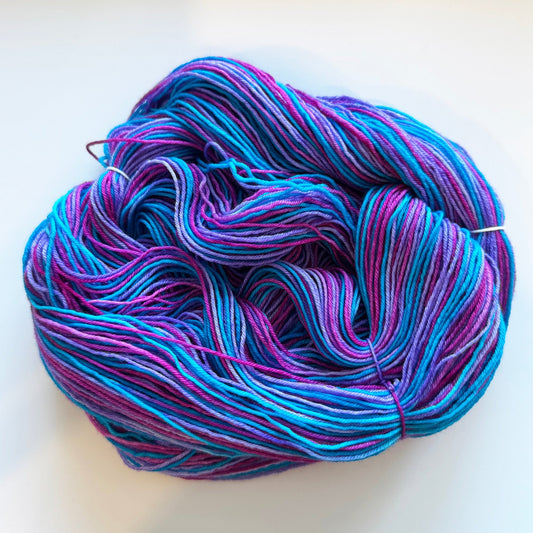 Hand-dyed sock yarn in magenta, turquoise, and purple, Orchid Cascade Stripe colorway