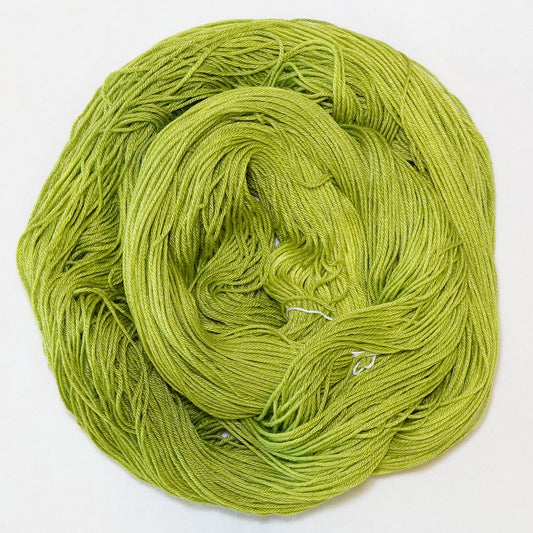 Hand-dyed fingering weight yarn in tonal electric chartreuse green.