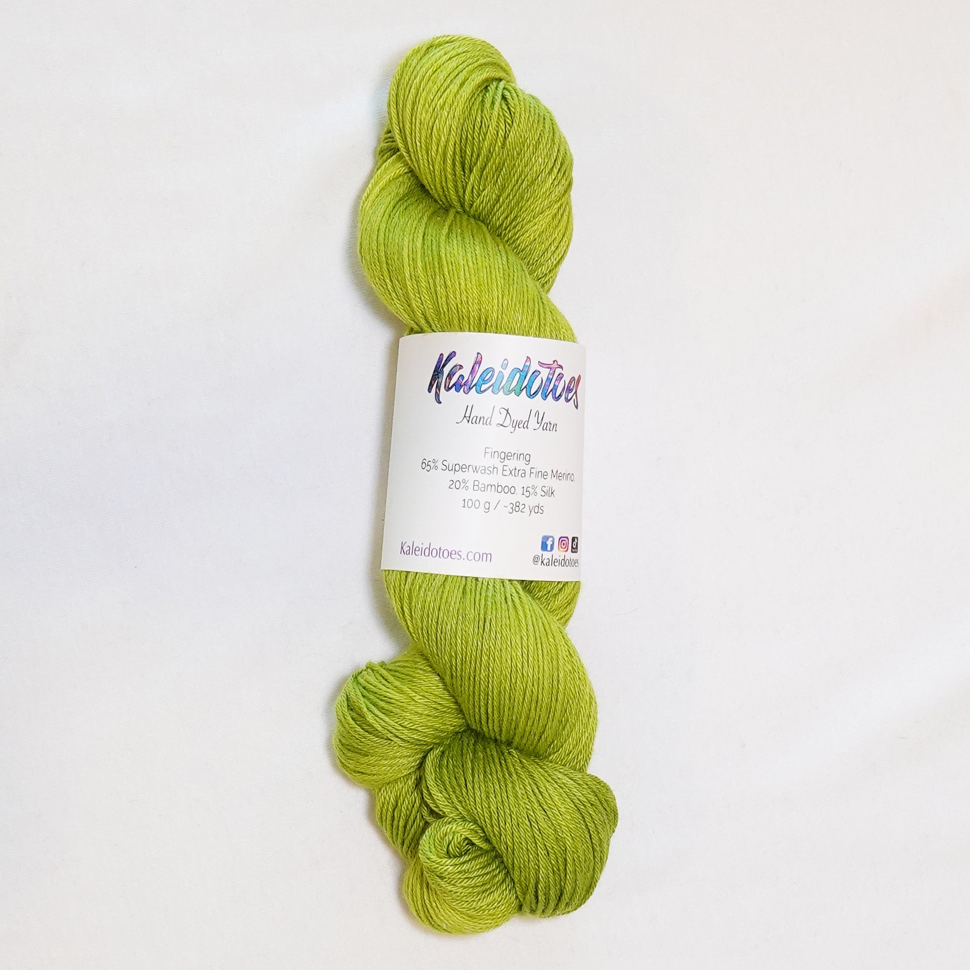 Hand-dyed fingering weight yarn in tonal electric chartreuse green.