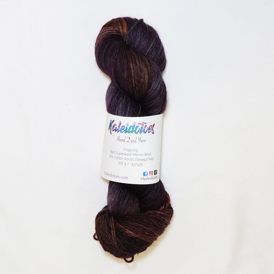 Hand-dyed fingering weight yarn in deep plum, smoky violet, rust, amber, and magenta with shadowy tonal depth throughout.