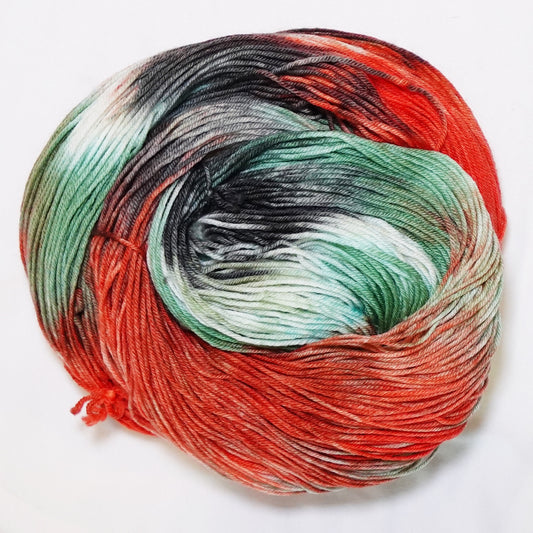 Hand-dyed fingering weight yarn with salmon orange, wasabi green, deep black-green nori, and white in a bold variegated colorway.
