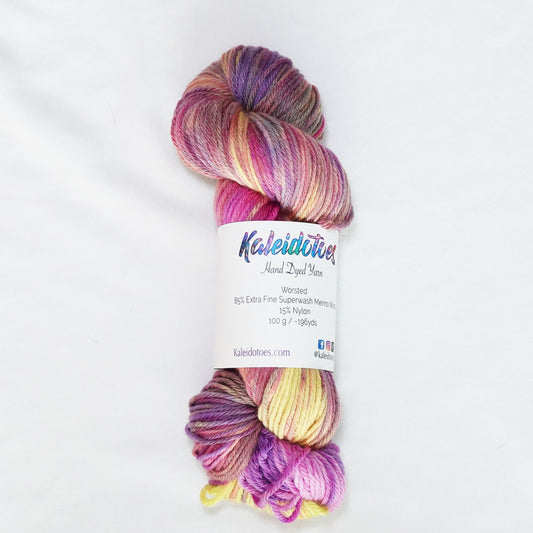 Hand-dyed worsted weight yarn in hot magenta, peach, lavender, yellow, and mauve with soft color transitions throughout.