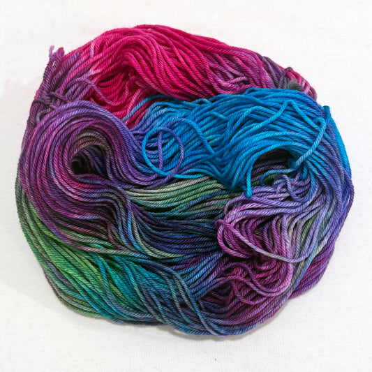 Hand-dyed worsted-weight yarn in jewel tones of turquoise, fuchsia, purple, and green — Velvet Voltage colorway by Kaleidotoes, radiant and electric.