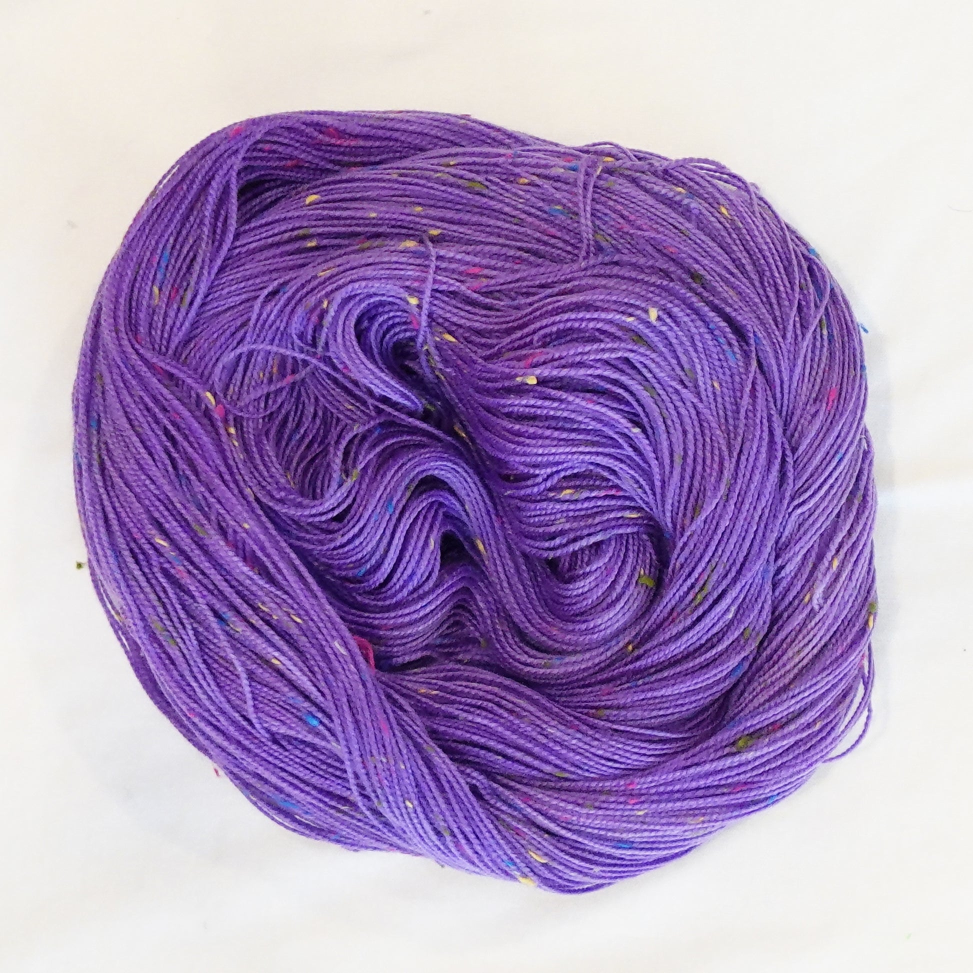Hand-dyed yarn in rich violet tones with colorful flecks — bold, expressive, and full of contrast.