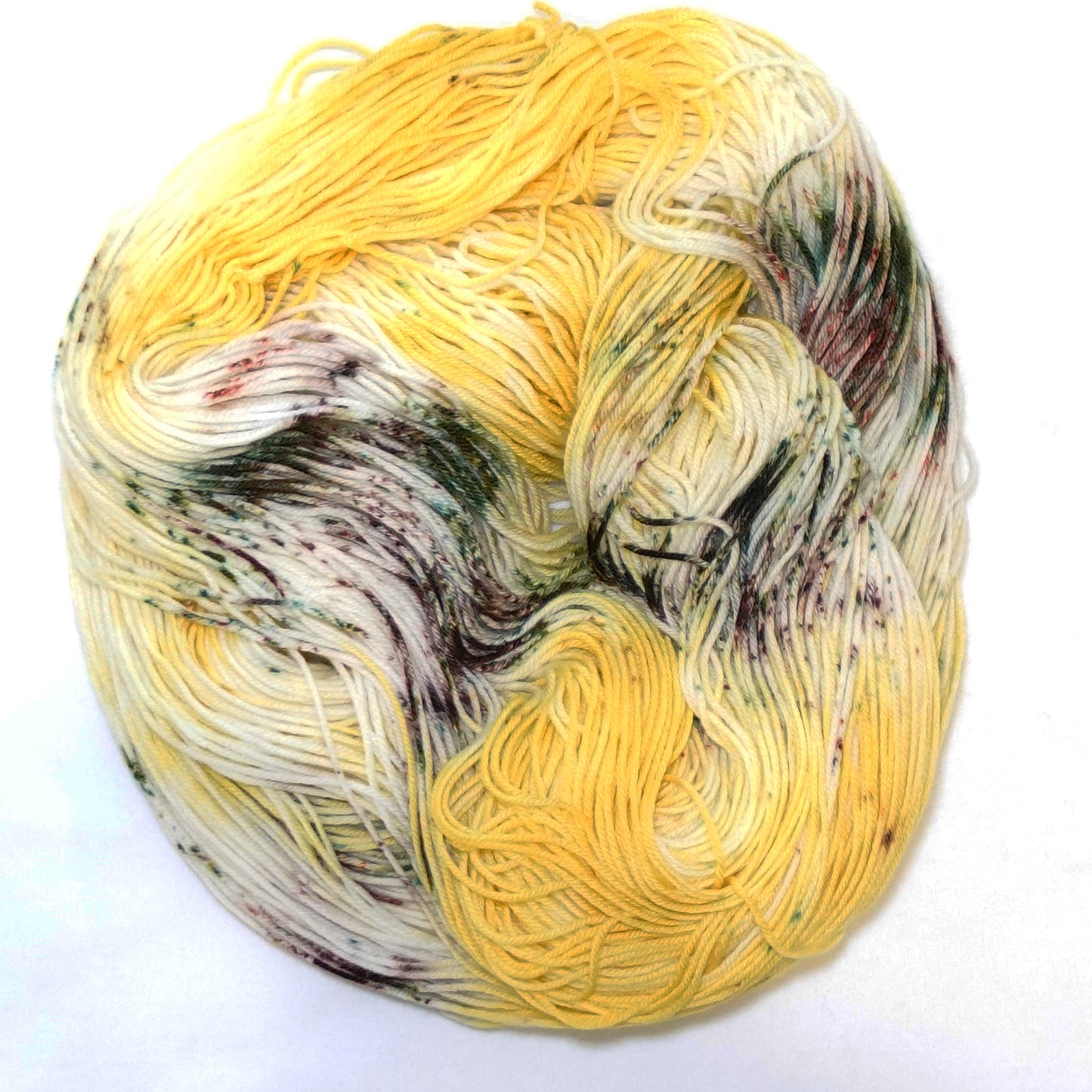 Hand-dyed yarn in rich sunflower yellow with earthy green and brown speckles — warm, grounded, and inspired by wild sunflower fields.