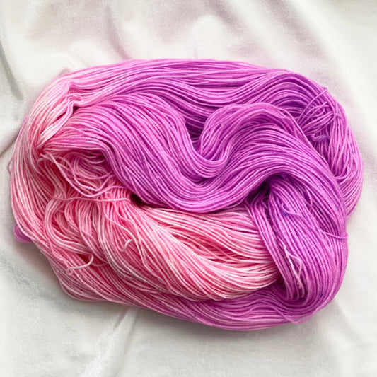 Hand-dyed sock yarn in pastel pink, vibrant pink, and orchid tones, Hollyhock colorway