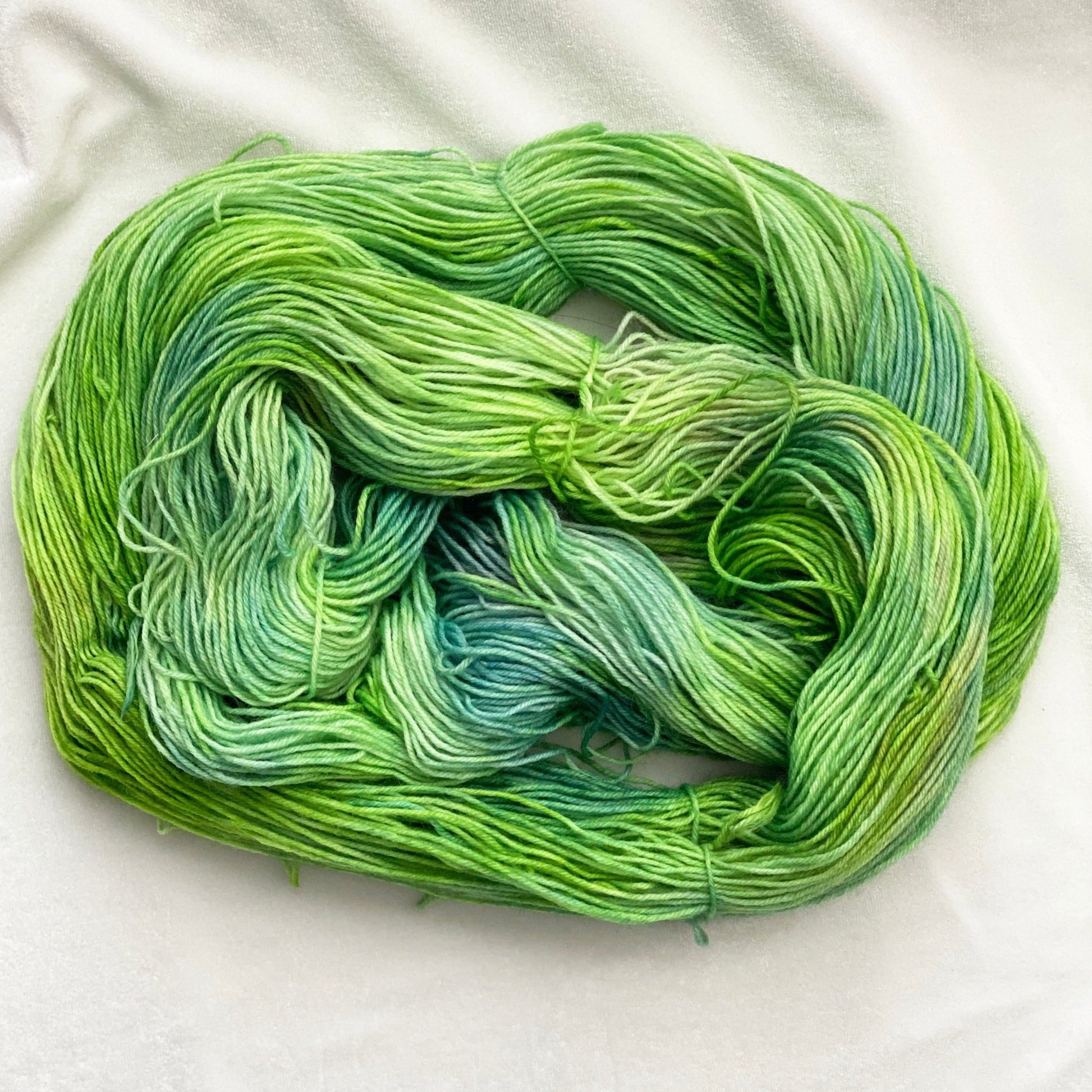 Spring Meadow fingering weight yarn in shades of green, blue, and purple